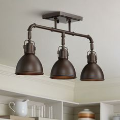 three lights hanging from the ceiling in a kitchen