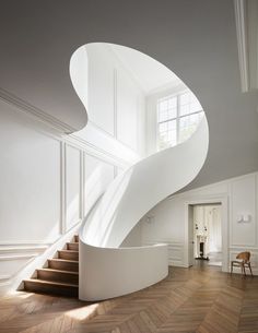 a white spiral staircase in an empty room