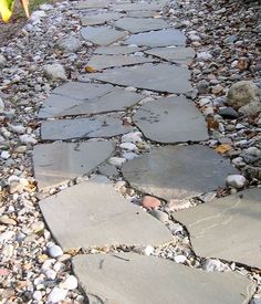 an image of a stone path that is in the middle of gravel and rocks on the ground