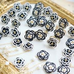 there are many black and white flowers on the table in front of a gold frame