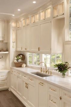 White Kitchen With Cream Countertops, Cream Kitchen White Appliances, Cream Kitchen Cabinets With Gold Hardware, Cream Kitchen With Gold Hardware, White Kitchen With Gold Fixtures, Cream Cabinets Stainless Appliances, Old White Cabinets Kitchen, White Kitchen Cabinets With Tile Backsplash, White Wood And Gold Kitchen