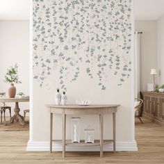 a table with vases on it in front of a wall covered in blue flowers