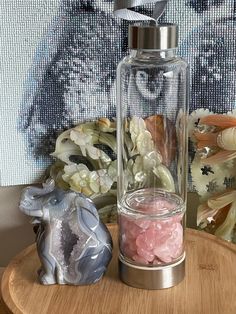 a glass jar filled with candy sitting on top of a wooden table next to an elephant figurine