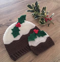 two knitted christmas hats sitting on top of a wooden floor