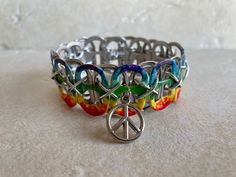 "Peace, love and pop tabs! Get groovy with this hand-painted \"tie dye\" bracelet, which features a peace sign charm. The bracelet pictured is made of 12 tabs and is about 8 inches in length.  Bracelets are strung with elastic cord for comfort, and can fold flat for storage or travel. Please choose your size at checkout: XS - 10 tabs, approx. 6 inches (child-size wrist) S - 11 tabs, approx 7 inches (small-boned wrist) M - 12 tabs, approx. 8 inches (medium-boned wrist) L - 13 tabs, approx. 9 inch Punk Jewelry Diy, Can Tab Bracelet, Pop Tab Bracelet, Tab Bracelet, Pop Tab Crafts, Monster Crafts, Pop Tabs, Hippie Peace, Fun Jewelry