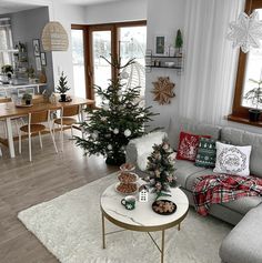 a living room filled with furniture and a christmas tree in the middle of the room