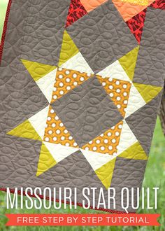 the missouri star quilt is on display in front of a green grass field with an orange and