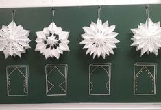 paper snowflakes hanging on a green wall