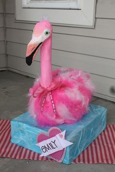 a pink flamingo sitting on top of a blue box