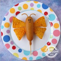 a plate topped with a bug shaped cracker on top of a white and blue polka dot plate