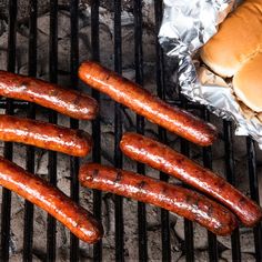 hot dogs and hamburgers are cooking on the grill