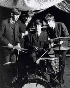 an old black and white photo of some people playing drums