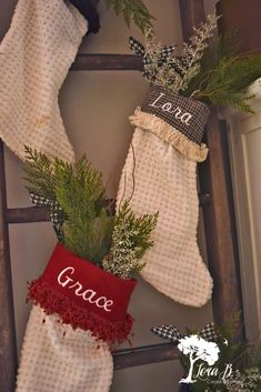 christmas stockings hung on an old ladder decorated with greenery and red stocking saying grace