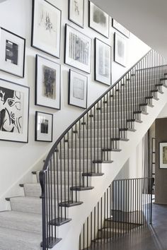 a staircase with pictures on the wall above it