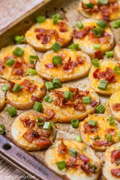 baked potato skins with bacon and green onions on a baking sheet, ready to be eaten