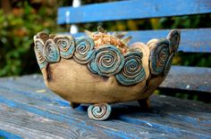 a ceramic bowl sitting on top of a wooden bench