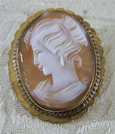 "I am offering you this truly exquisite vintage Italian Style fancy carved cameo pin pendant charm brooch, all done in 12 K yellow gold. What a fantastic opportunity to purchase a most uniquely shaped fancy large cameo, with an amazing very raised convex female cameo. What a spectacular design....so very elegant yet simple at the same time. The cameo is large and has fantastic meticulous carving, with extreme depth and detail to it, depicting a gorgeous female figurines' side profile , with love Vintage Italian Style, Fancy Braids, Cameo Jewelry, Pin Pendant, Gold Band Ring, Side Profile, Rochester Ny, Silver Band Ring, Yellow Gold Pendants