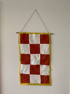 Handmade quilted wall hanging, checkered print created with scrap pieces of hand dyed red linen and white linen fabric.  Backing is hand dyed cotton.  Hanging is connected to a wooden stick by thread and hung with braided embroidery thread. Braided Embroidery, Sewing Products, Quilt Wall Hanging, White Linen Fabric, Quilted Wall Hanging, Textile Wall Hangings, Fabric Wall Hanging, Halloween Quilts, Checkered Print