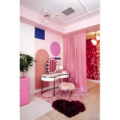 a pink and purple room with a desk, chair, mirror and rug on the floor