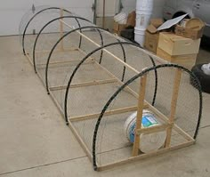 a set of three cages sitting on top of a floor next to a garage door