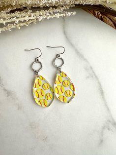 yellow and white tear shaped earrings with baseballs on them