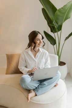 a woman sitting on a couch using a laptop computer