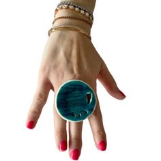 Statement boho jewelry, beach pottery ring, gift for her are you ready  Express your individuality with this beautiful cocktail ring. Mediterranean green and blue glaze. The pottery has been churned and finished in Australian sea-waters and sand, then glazed and fired to make a magical delight. The diameter is 2.1 inches or 5.3 centimetres and it has an adjustable ring shank. You won't be on your own for long anywhere with this conversation starter.  Look glamorous and be the center of attention always. High temperature fired Ceramic. Handmade with provocative intent :) I am convo friendly and welcome your comment. Leanne Blue Bohemian Rings For The Beach, Blue Bohemian Rings For Beach, Bohemian Blue Rings For Beach, Unique Handmade Ceramic Jewelry, Turquoise Enamel Ring Gift, Turquoise Enamel Ring As Gift, Handmade Open Ring Jewelry For Beach, Unique Handmade Adjustable Enamel Ring, Blue Artsy Jewelry For Beach