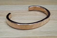 "*Please measure your WRIST for accurate sizing before ordering.* This hammered solid copper cuff bracelet is thick, sturdy, and should last a lifetime. This is 100% pure solid copper all of the way through with no coatings of any sort. The bracelet is 1/4 of an inch (8 mm) wide and 1/8 of an inch (3 mm) thick with a hammer textured finish. I cut, shape, hammer, (engrave if requested) and finish each bracelet by hand. Photo nine compares this bracelet to our thicker copper cuff. Please check our Mens Copper Bracelet, Hammered Cuff Bracelet, Cuff Bracelets Handmade, Copper Cuff Bracelet, Copper Cuff, Copper Bracelet, Copper Jewelry, Bracelet Gift, Gift For Him