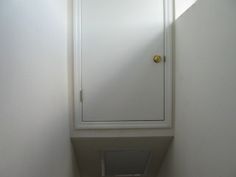 an empty white bathroom with a mirror above the sink