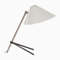 a white table lamp with two black sticks sticking out of it's side and one light on top