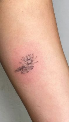 a small waterlily tattoo on the arm