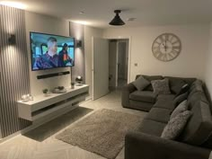 a flat screen tv mounted to the wall in a living room next to a couch