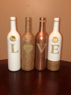 three wine bottles with the letter e painted on them are sitting on a table next to each other