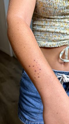 a woman's arm with small black dots on her left side and the word, fairytats