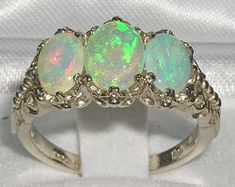 *This gorgeous ring is made from 9K White Gold prong setting with Natural Semi-precious Fiery Opals.*Total gems weight; Opal 1.75ct  This is an English Made impressive ring set with Center 8x6 mm (0.32" x 0.24") and two 7x5 mm (0.28" x 0.20") beautiful oval cut Large Fiery Opals set in a Pure Solid White Gold Antique / Victorian style prong setting. This ring has a good solid feel, a nice weight and a good thick shank.*Total Height 5mm, Width 16mm, Length 11mm Completely made from Solid English Trilogy Ring, Carved Ring, English Antiques, Opal Earrings, Australian Opal, Opal Jewelry, Opal Rings, Pink Tourmaline, Antique Style