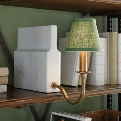 a lamp that is on top of a book shelf next to some books and pictures