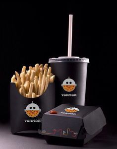 french fries in black containers next to a drink