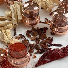 various spices and herbs on a white counter top, including dried gourmets