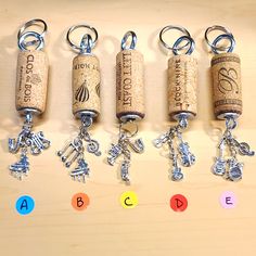 four wine cork key chains with charms attached to them