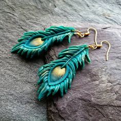 I make these peacock feather earrings of Polymer clay, gold Mika powder and gold plated brass which is of course hypoallergenic. These feather earrings are vegan and super lightweight and very confortable to wear. The colour changes with the light between a deep turquoise and shimmery peacock greenish blue.  Choose your preferred earring hooks from the menu either gold plated brass or 9k gold plated 925 Sterling silver.  Are they a gift? Gift wrap is available and can be purchased with the earri Clay Peacock Feather, Peacock-colored Bohemian Earrings For Gift, Bohemian Peacock Earrings For Gift, Peacock Bohemian Earrings For Gift, Bohemian Peacock Earrings As Gift, Peacock Bohemian Earrings As Gift, Turquoise Feather Jewelry As Gift, Turquoise Feather Jewelry As A Gift, Green Peacock Design Jewelry Gift