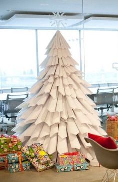 a paper christmas tree sitting on top of a table next to a chair and boxes