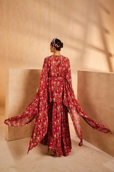 Featuring a floral-printed kaftan and sharara. The kaftan’s neckline is embroidered by hand using a mirror, sequences, and beadwork. The tie-up is accentuated with mirrors and the kaftan hem is accentuated with antique gold coins.From Aneesh Agarwaal's Seher collection.DELIVERY TIMEPlease allow 8-12 weeks for your outfit to arrive.FABRIC DETAILSChinonProfessional cleaning only. Bohemian Dresses With Cape Sleeves For Festive Occasions, Festive Bohemian Dress With Cape Sleeves, Red Silk Anarkali Set With Printed Motifs, Bohemian Georgette Sets With Cape Sleeves, Festive Floral Print Dress With Cape Sleeves, Festive Dresses With Floral Print And Cape Sleeves, Traditional Drape Palazzo Set With Printed Motifs For Reception, Georgette Palazzo Set With Printed Motifs For Reception, Reception Palazzo Set With Traditional Drape And Printed Motifs