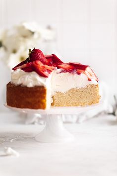 a piece of cake with white frosting and strawberries on top