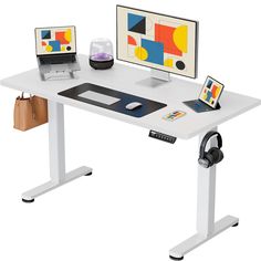 a computer desk with two monitors and a laptop sitting on it's standup