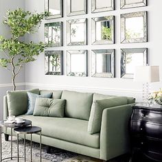 a living room filled with furniture and mirrors on the wall