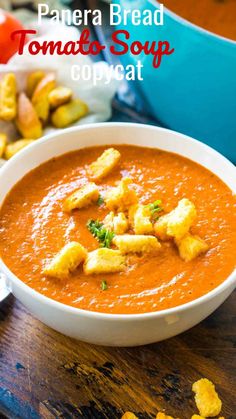 a bowl of tomato soup with croutons on the side