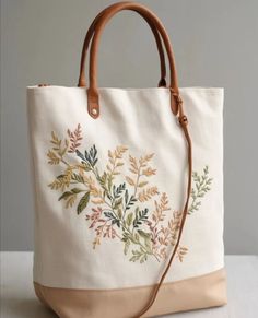 a handbag with embroidered leaves on it