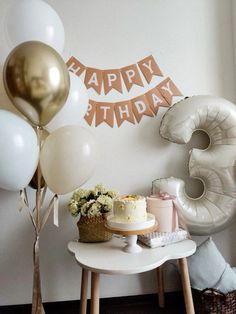 a birthday cake on a table with balloons and streamers