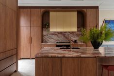 a kitchen with marble counter tops and wooden cabinets