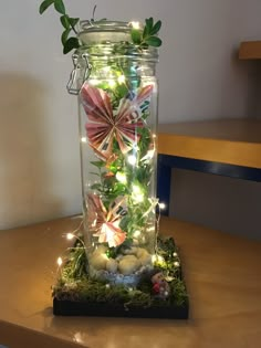 a glass jar filled with lights and flowers